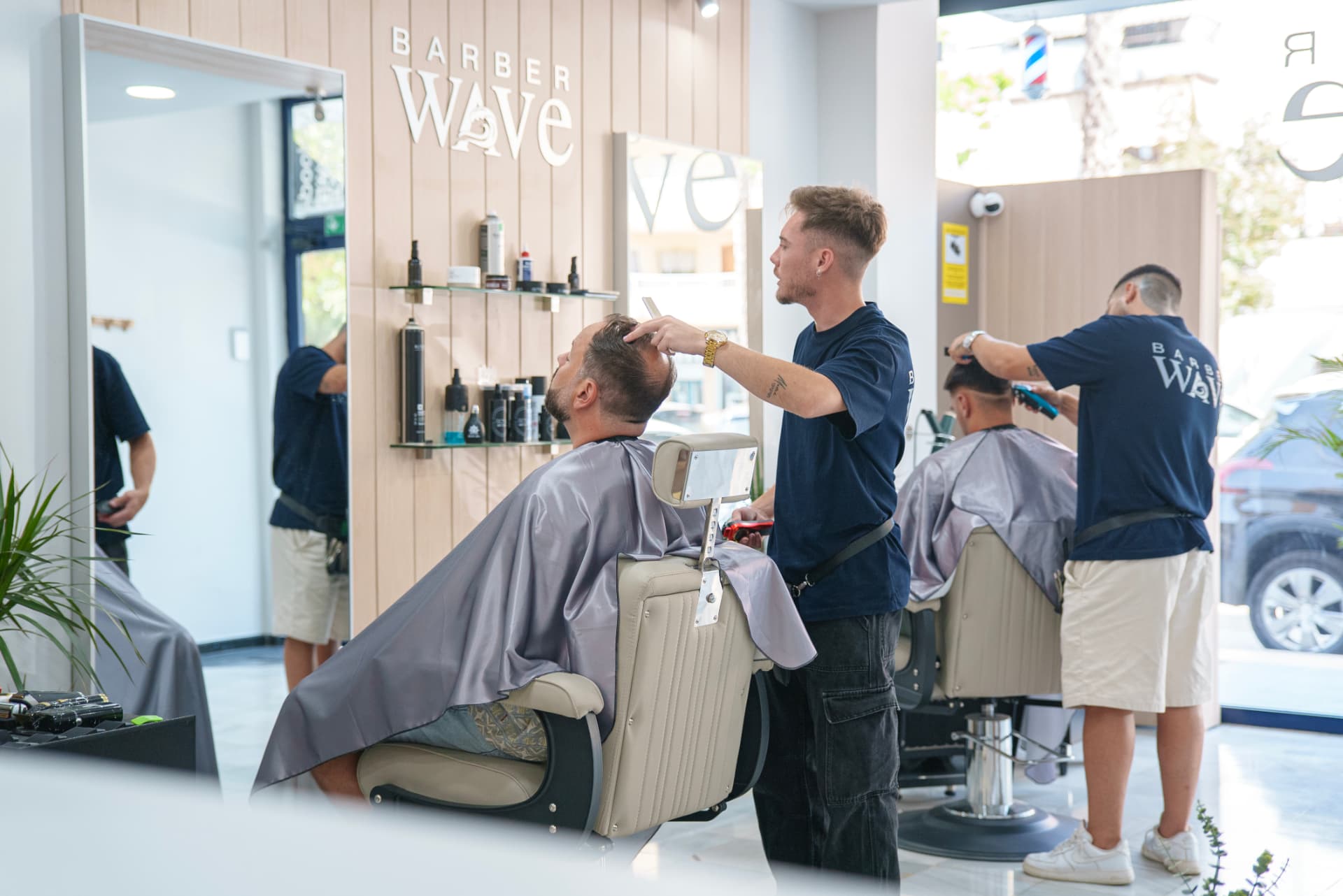 Barbero de Barber Wave preparando a un cliente en el local de Torre del Mar